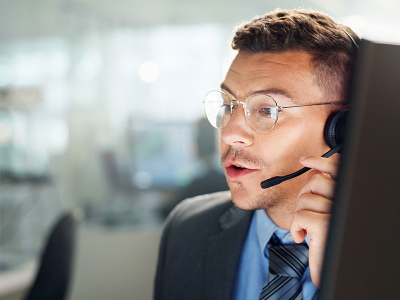 Customer service representative wearing a headset, assisting clients with property insurance claims and inquiries