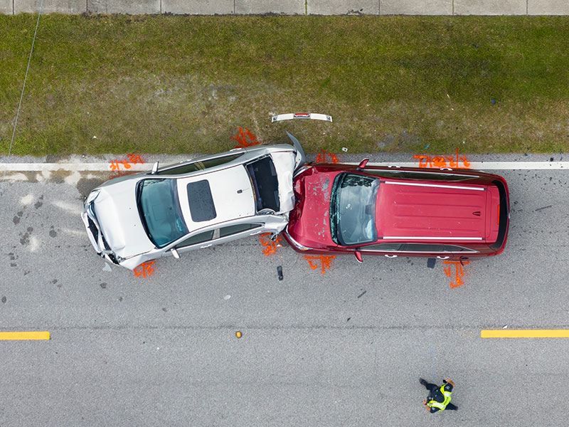 Two-vehicle side collision on a road, emphasizing the need for auto insurance and safe driving practices to prevent loss