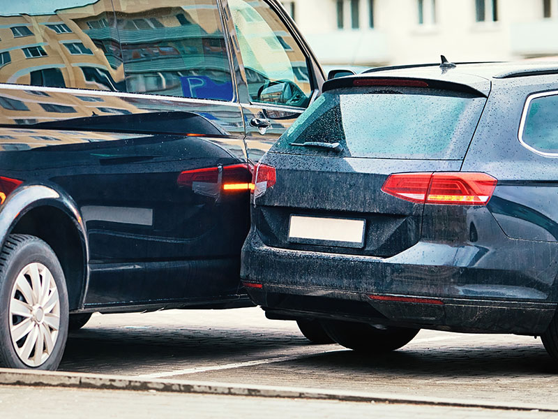 Two vehicles involved in a minor collision in a parking lot—illustrating importance of auto insurance for such claims